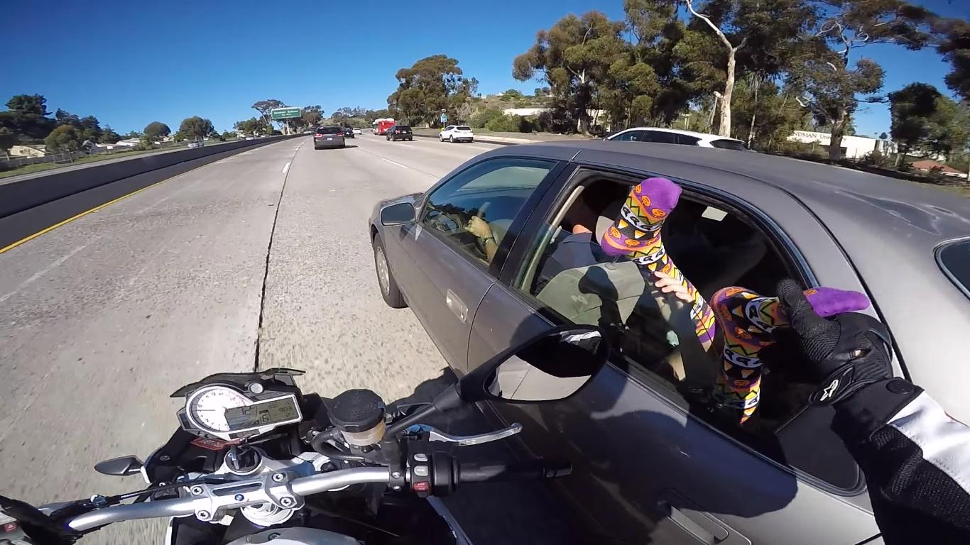 Man Riding Motorcycle Grabs Someone's Foot on the Freeway